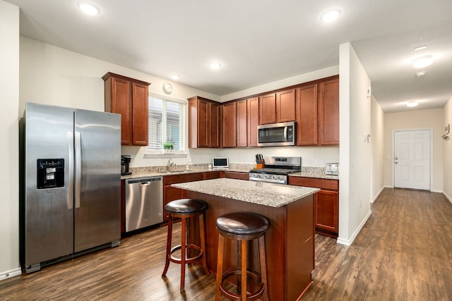 14619 Jasper Stream Ct, Houston, TX 77069 - kitchen featuring stainless steel appliances, dark wood-style floors, a center island, a kitchen bar, and light stone counters