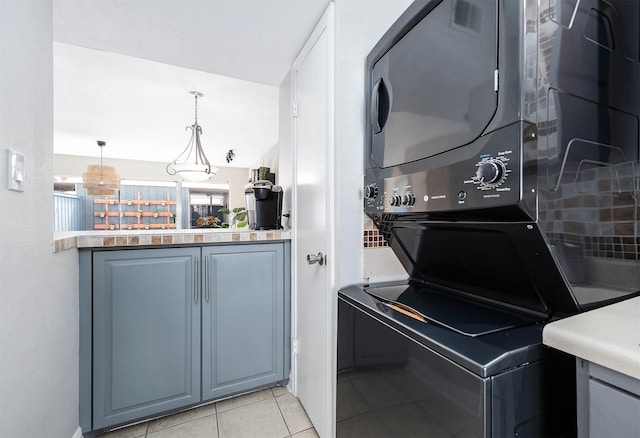 2011 Winrock Blvd Unit 172, Houston, TX 77057 - laundry area with stacked washer and clothes dryer and light tile patterned floors