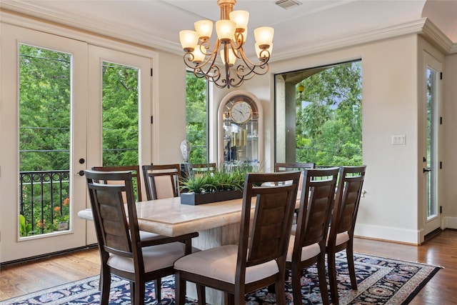 5520 Mcculloch Cir, Houston, TX 77056 - dining space featuring healthy amount of natural light, a chandelier, wood finished floors, crown molding, and baseboards