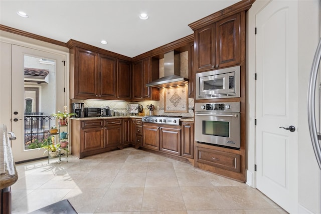 5520 Mcculloch Cir, Houston, TX 77056 - kitchen with appliances with stainless steel finishes, wall chimney range hood, decorative backsplash, recessed lighting, and light tile patterned floors