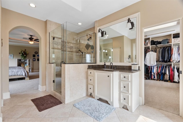 5520 Mcculloch Cir, Houston, TX 77056 - ensuite bathroom featuring a ceiling fan, vanity, a stall shower, a spacious closet, and tile patterned floors
