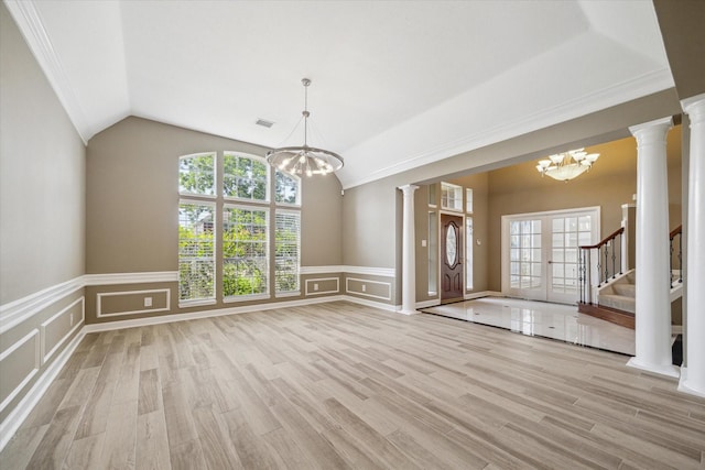 42 Stalybridge St, Sugar Land, TX 77479 - entryway with a chandelier, ornate columns, a decorative wall, a wainscoted wall, and lofted ceiling
