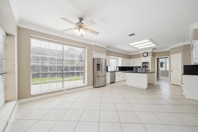 42 Stalybridge St, Sugar Land, TX 77479 - kitchen with stainless steel appliances, a ceiling fan, dark countertops, healthy amount of natural light, and ornamental molding