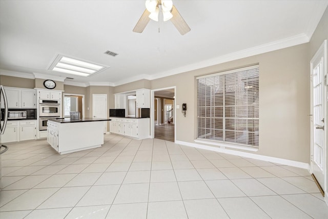 42 Stalybridge St, Sugar Land, TX 77479 - kitchen with stainless steel appliances, dark countertops, ornamental molding, white cabinetry, and ceiling fan