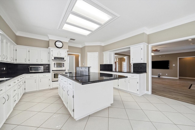 42 Stalybridge St, Sugar Land, TX 77479 - kitchen featuring stainless steel appliances, tasteful backsplash, light tile patterned floors, crown molding, and dark countertops
