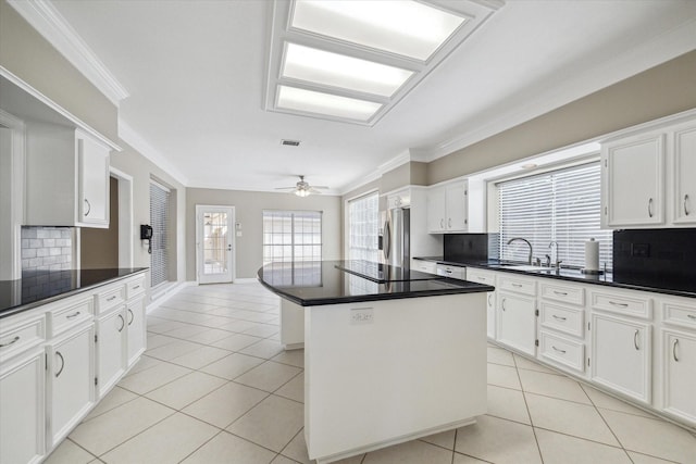 42 Stalybridge St, Sugar Land, TX 77479 - kitchen featuring stainless steel refrigerator with ice dispenser, a sink, tasteful backsplash, light tile patterned floors, and a kitchen island