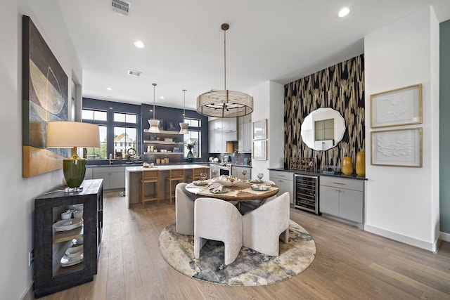1720 Sedola Ln, Houston, TX 77055 - dining space featuring wine cooler, light wood-style floors, recessed lighting, baseboards, and bar area