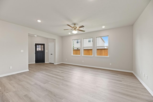 18810 Lucas Michael Way, New Caney, TX 77357 - unfurnished living room with ceiling fan, plenty of natural light, recessed lighting, light wood-style floors, and baseboards