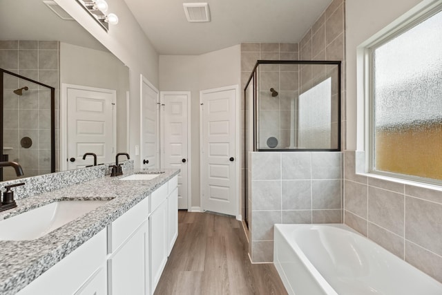 18810 Lucas Michael Way, New Caney, TX 77357 - bathroom with a shower stall, a bath, double vanity, and wood finished floors