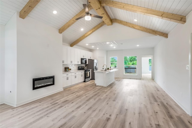 4014 Linder St, Houston, TX 77026 - unfurnished living room with recessed lighting, light wood-type flooring, a glass covered fireplace, ceiling fan, and a sink