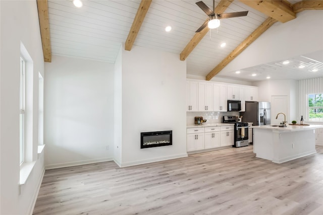 4014 Linder St, Houston, TX 77026 - kitchen with appliances with stainless steel finishes, white cabinets, light wood-style flooring, a sink, and light countertops