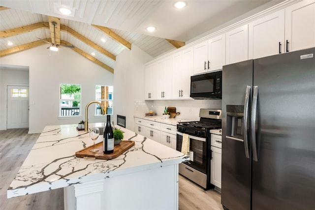 4014 Linder St, Houston, TX 77026 - kitchen featuring refrigerator with ice dispenser, black microwave, stainless steel range with gas cooktop, light wood-style floors, and recessed lighting