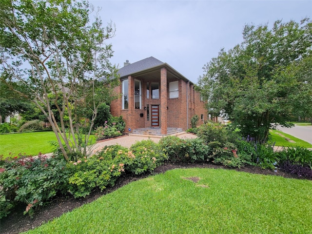 4900 Willow St, Bellaire, TX 77401 - view of front of house with brick siding, a front yard, and a chimney