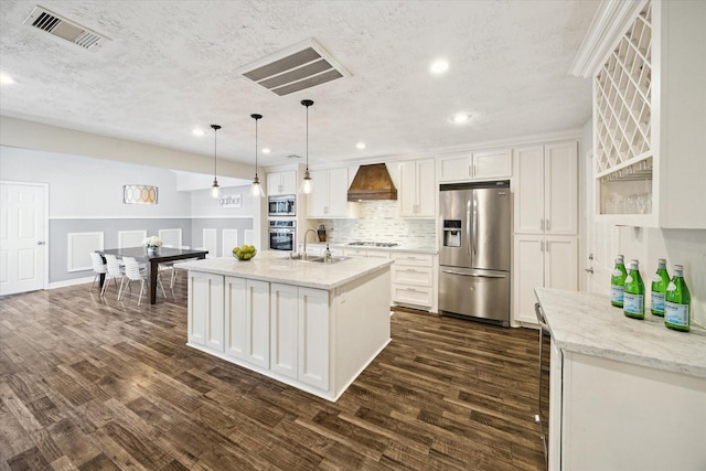11102 Hillcroft St, Houston, TX 77096 - kitchen featuring appliances with stainless steel finishes, custom range hood, a sink, white cabinets, and recessed lighting