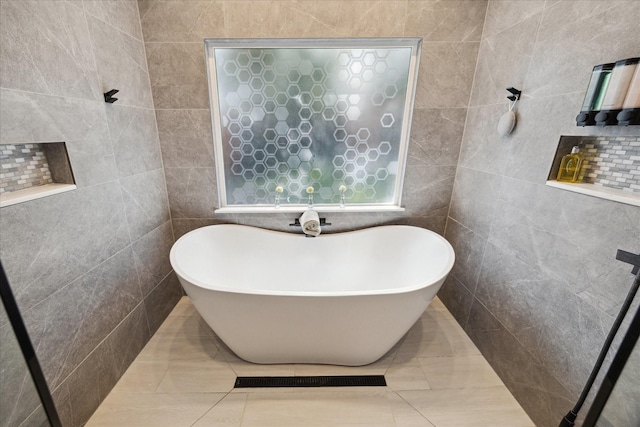 11102 Hillcroft St, Houston, TX 77096 - bathroom featuring a freestanding bath, tile walls, and tile patterned flooring