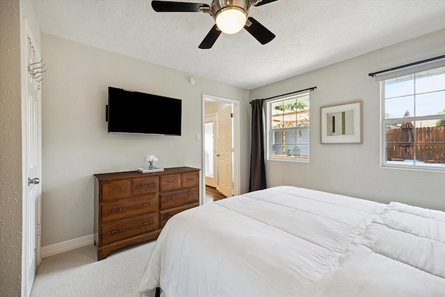 11102 Hillcroft St, Houston, TX 77096 - bedroom featuring baseboards, carpet flooring, a textured ceiling, multiple windows, and ceiling fan