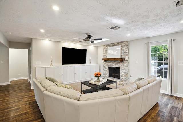 11102 Hillcroft St, Houston, TX 77096 - living room featuring baseboards, dark wood finished floors, a fireplace, a ceiling fan, and a textured ceiling