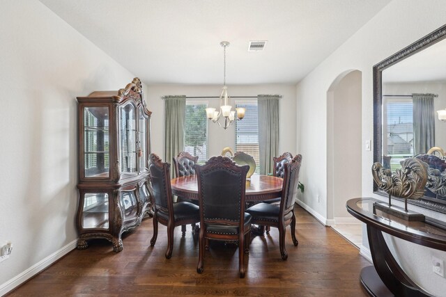 3403 Majestic Pine Ln, Rosenberg, TX 77471 - dining space with a chandelier, arched walkways, plenty of natural light, and dark wood finished floors