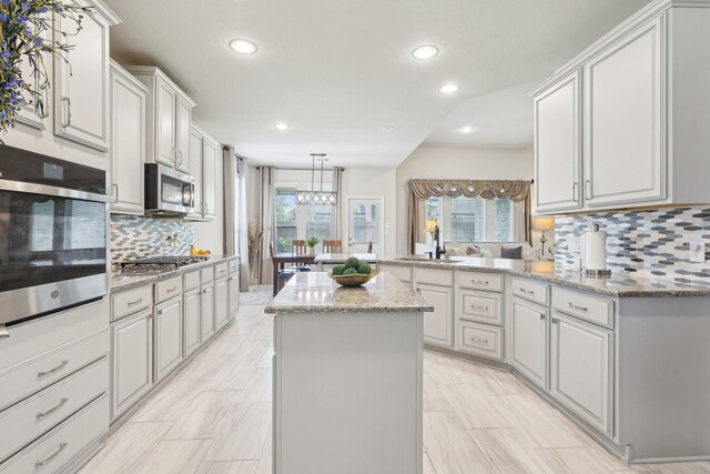 3403 Majestic Pine Ln, Rosenberg, TX 77471 - kitchen featuring stainless steel appliances, a peninsula, recessed lighting, healthy amount of natural light, and decorative backsplash