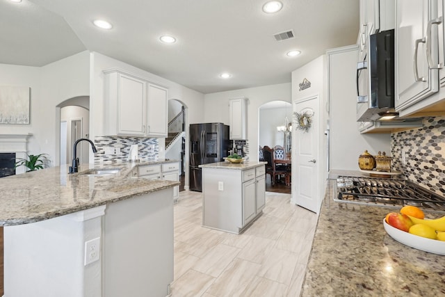 3403 Majestic Pine Ln, Rosenberg, TX 77471 - kitchen with arched walkways, stainless steel appliances, a sink, tasteful backsplash, and recessed lighting