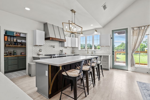 50 Berry St, Coldspring, TX 77331 - kitchen with wall chimney exhaust hood, light countertops, tasteful backsplash, vaulted ceiling, and light wood-type flooring