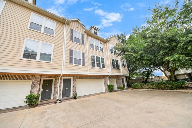 3001 Murworth Dr Unit 103, Houston, TX 77025 - townhome / multi-family property featuring a garage, concrete driveway, and brick siding
