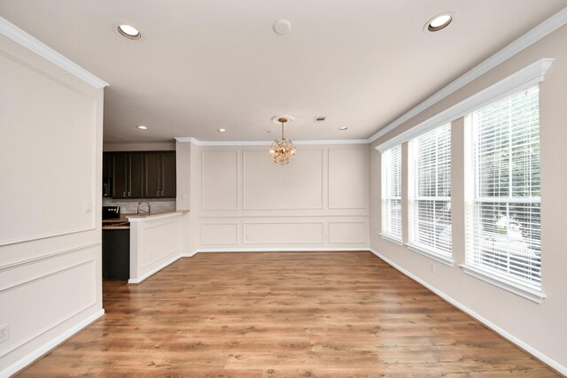 3001 Murworth Dr Unit 103, Houston, TX 77025 - unfurnished dining area featuring recessed lighting, ornamental molding, light wood finished floors, and a sink