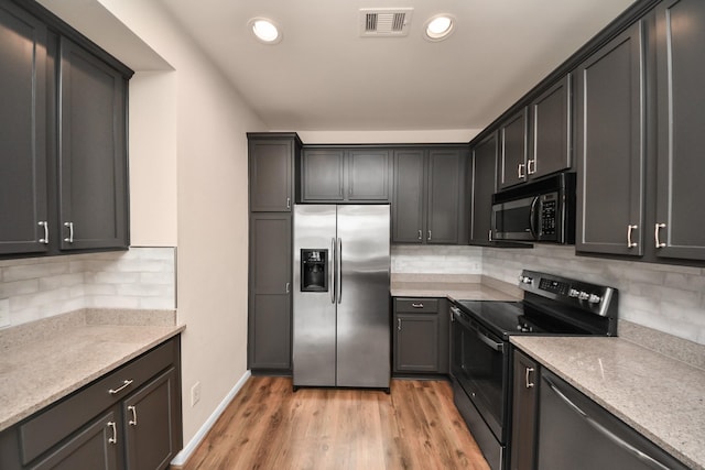 3001 Murworth Dr Unit 103, Houston, TX 77025 - kitchen featuring stainless steel appliances, decorative backsplash, light wood-style floors, recessed lighting, and baseboards