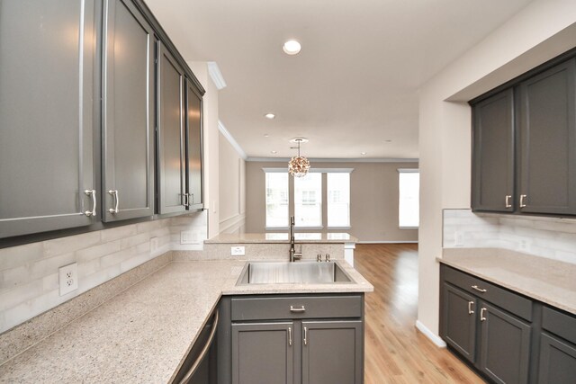 3001 Murworth Dr Unit 103, Houston, TX 77025 - kitchen with a sink, a peninsula, tasteful backsplash, light countertops, and light wood-type flooring