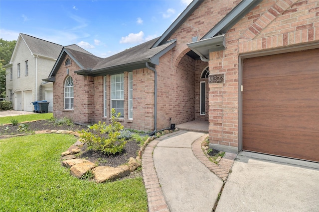 18327 Marlin Waters Dr, Humble, TX 77346 - property entrance with brick siding, a lawn, a garage, and a shingled roof