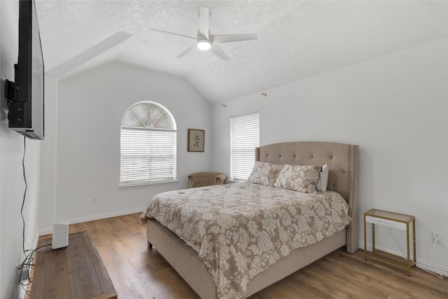 18327 Marlin Waters Dr, Humble, TX 77346 - bedroom featuring wood finished floors, a textured ceiling, baseboards, a ceiling fan, and vaulted ceiling