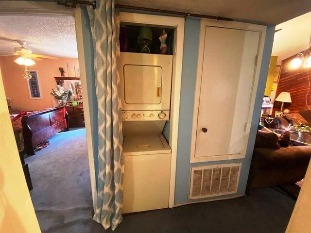 10049 Westpark Dr Unit 136, Houston, TX 77042 - laundry room featuring stacked washer and clothes dryer, a ceiling fan, carpet, and a textured ceiling