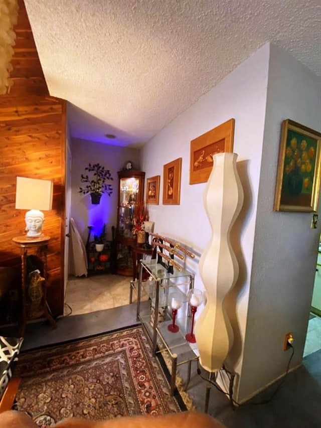 10049 Westpark Dr Unit 136, Houston, TX 77042 - hallway featuring a textured ceiling and wood walls