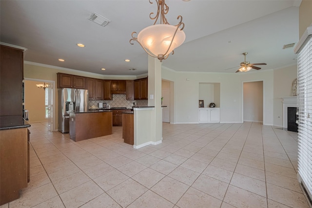 4515 Tremont Glen Ln, Katy, TX 77494 - kitchen featuring open floor plan, dark countertops, stainless steel fridge, a kitchen island, and light tile patterned flooring