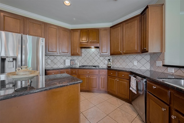 4515 Tremont Glen Ln, Katy, TX 77494 - kitchen featuring appliances with stainless steel finishes, dark stone countertops, brown cabinetry, decorative backsplash, and ornamental molding
