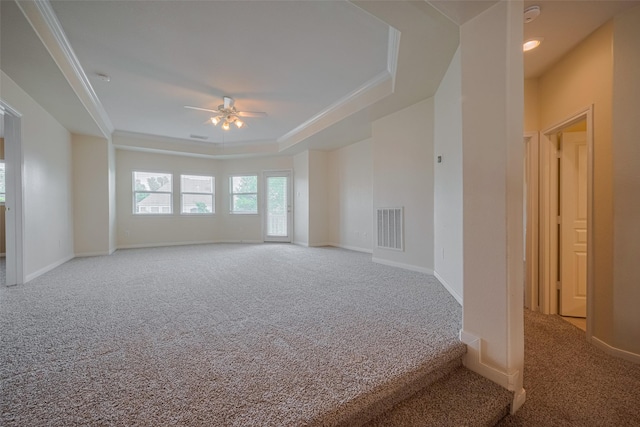 4515 Tremont Glen Ln, Katy, TX 77494 - unfurnished living room with carpet flooring, a ceiling fan, a raised ceiling, baseboards, and crown molding