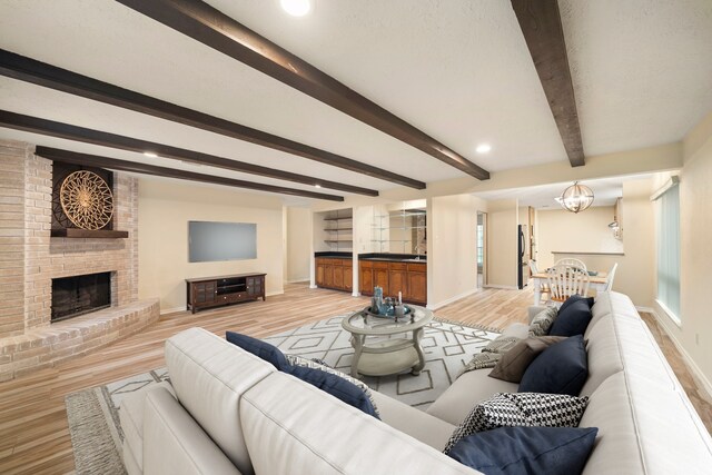 2311 Jackson Ln, League City, TX 77573 - living room with beam ceiling, wood finished floors, baseboards, a brick fireplace, and recessed lighting