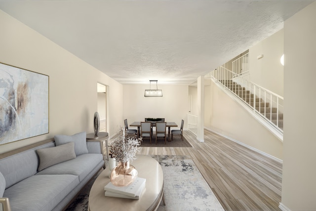 2311 Jackson Ln, League City, TX 77573 - living area featuring wood finished floors, a textured ceiling, baseboards, and stairway