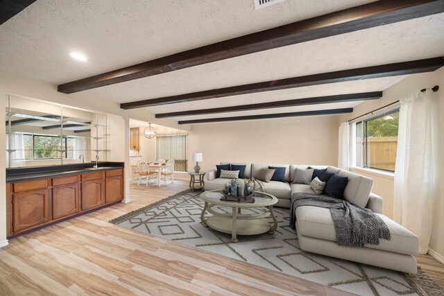 2311 Jackson Ln, League City, TX 77573 - living room featuring a textured ceiling, light wood finished floors, plenty of natural light, beamed ceiling, and recessed lighting