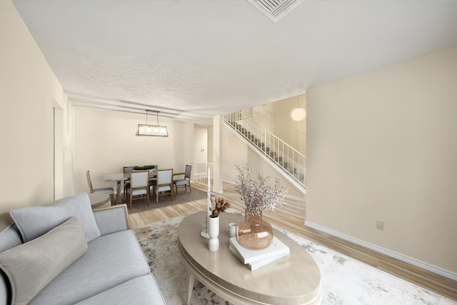 2311 Jackson Ln, League City, TX 77573 - living area featuring stairs, light wood-style flooring, and baseboards