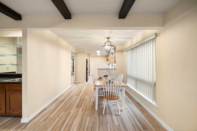 2311 Jackson Ln, League City, TX 77573 - dining room featuring beam ceiling, light wood-style floors, baseboards, and a chandelier