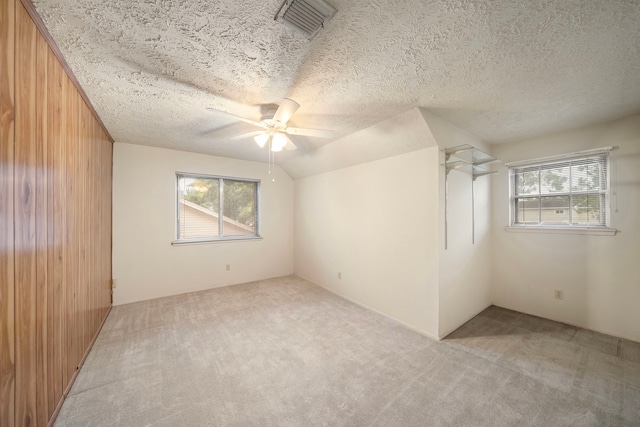 2311 Jackson Ln, League City, TX 77573 - unfurnished room featuring light carpet, healthy amount of natural light, ceiling fan, wooden walls, and a textured ceiling