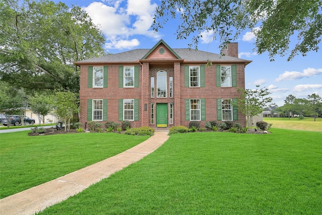 1805 Twin Oaks St, Friendswood, TX 77546 - colonial home with a chimney, a front lawn, and brick siding