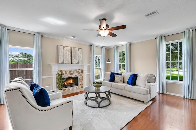 1805 Twin Oaks St, Friendswood, TX 77546 - living area featuring a ceiling fan, wood finished floors, plenty of natural light, a lit fireplace, and crown molding