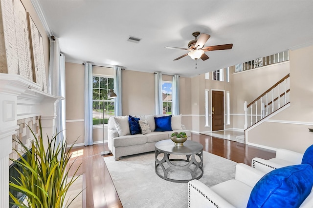 1805 Twin Oaks St, Friendswood, TX 77546 - living area featuring a ceiling fan, baseboards, stairs, wood finished floors, and a fireplace