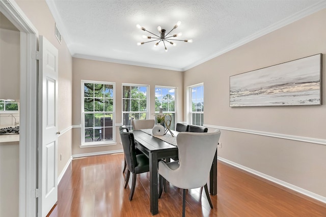 1805 Twin Oaks St, Friendswood, TX 77546 - dining room with wood finished floors, baseboards, a textured ceiling, a chandelier, and crown molding
