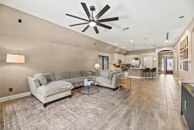 24747 Ballad Dr, Katy, TX 77493 - living room featuring arched walkways, a ceiling fan, light wood finished floors, baseboards, and healthy amount of natural light