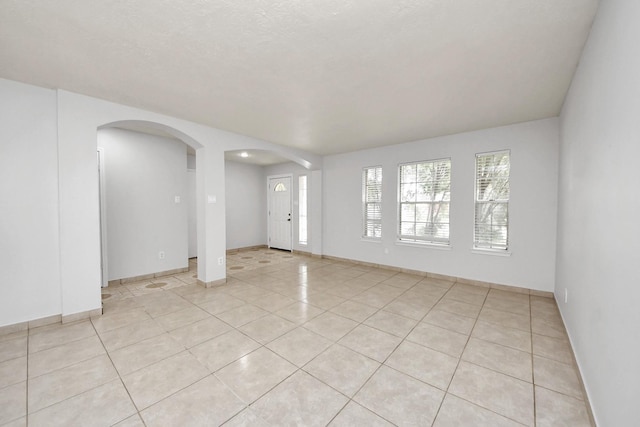 4310 Lucas Trace Ct, Houston, TX 77066 - spare room featuring arched walkways, light tile patterned floors, and baseboards