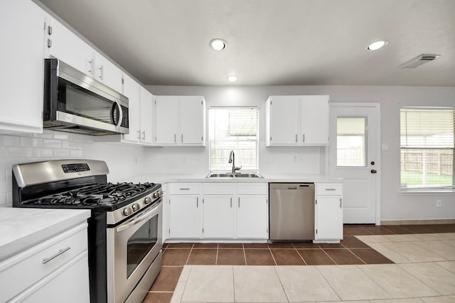 4310 Lucas Trace Ct, Houston, TX 77066 - kitchen with stainless steel appliances, a sink, light countertops, dark tile patterned floors, and recessed lighting
