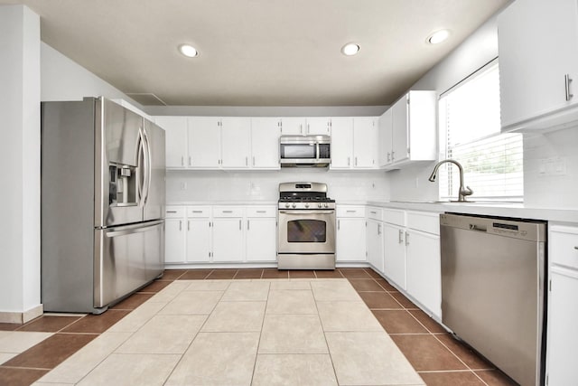 4310 Lucas Trace Ct, Houston, TX 77066 - kitchen with stainless steel appliances, light countertops, a sink, dark tile patterned flooring, and white cabinetry